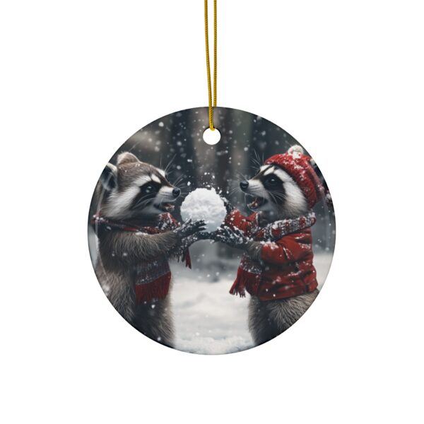 Festive Christmas ornament featuring two raccoons in winter attire sharing a snowball, perfect for holiday decor